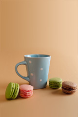 a cup of tea and macaron arranged in a beautiful composition on background