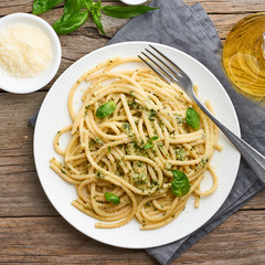 Pesto spaghetti pasta with basil, garlic, pine nuts, olive oil. Rustic table