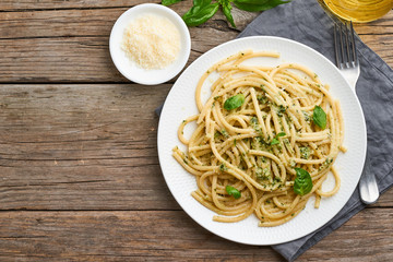Pesto spaghetti pasta with basil, garlic, pine nuts, olive oil. Copy space. Rustic table