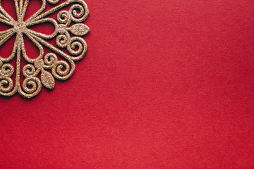 Fototapeta na wymiar Gold snowflake on red background. New Year decoration.Minimal