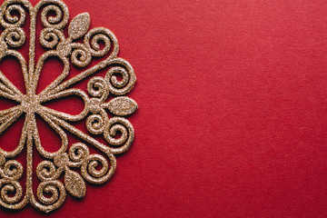 Fototapeta na wymiar Gold snowflake on red background. New Year decoration.Minimal