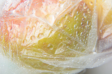 Bolsa de plástico llena de gotas de agua y en cuyo interior hay manzanas