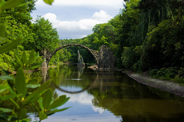Fototapeta na wymiar A romantic devil´s bridge made of stones in a park in Germany. 