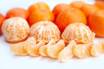 peeled tangerines on a white background. skins. slices