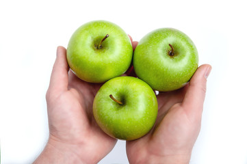 three ripe green apples in hand on white background