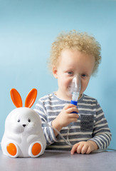 Sweet little boy having inhalation for easy cough at home. Allergy and health care concept. Copy...