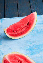cut of watermelon on blue background. Top view, flat lay.
