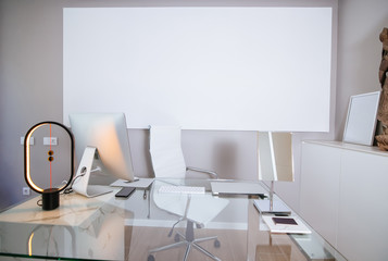 Doctor office in a modern private clinic with a large white screen in the background. Copy space.