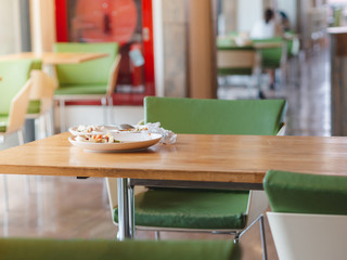White plates with food leftover and some garbages on wooden table. Food waste and environmental saving concept.