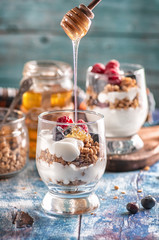 yogurt with granola and raspberries black chorynitsa and honey. yogurt in the blue on the table	