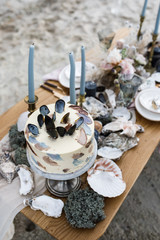 Sea wedding decor on the coast. Wedding cake and flowers at the event.