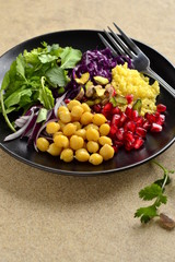 Healthy vegetarian salad. Millet, chickpea, pomegranate seeds, red cabbage, onions, arugula. Buddha bowl, vertical