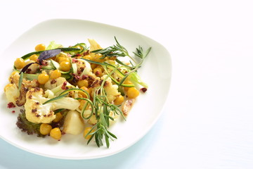 Roasted cauliflower with chickpeas, zucchini noodles and rosemary, salad, copy space