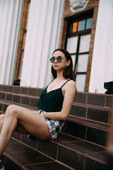 Sexy girl in sunglasses t-shirt and short shorts near the columns