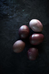 Dark purple eggs on a rough cement background