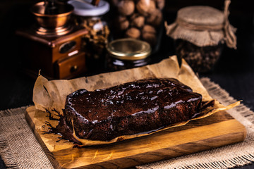 Brownie in chocolate syrup on baking paper.