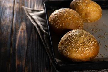 Homemade buns on burlap on wooden background