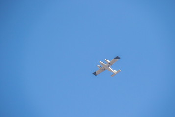 Obraz premium A small aircraft in flight isolated in a clear blue sky image with copy space in landscape format