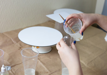 Mixing paints in plastic glasses for acrylic painting. Circle canvas waiting for blue and green paints on the craft paper background.. Selective focus