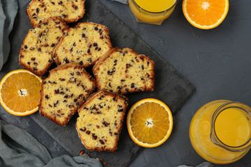 Cupcake with oranges and chocolate, located on a slate stand against a dark background