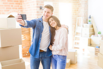 Beautiful young couple smiling happy taking a selfie photo with smartphone, very excited moving to a new home