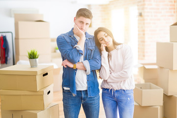 Beautiful young couple moving to a new house thinking looking tired and bored with depression...