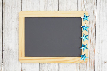 Blank chalkboard with  blue stars on weathered whitewash textured wood background