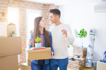 Fototapeta na wymiar Young asian couple holding keys of new house, smiling happy and excited moving to a new apartment