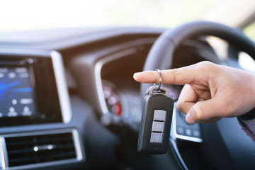 Car key, businessman hand holding over gives and show the car key interior the car.  transportation concept	