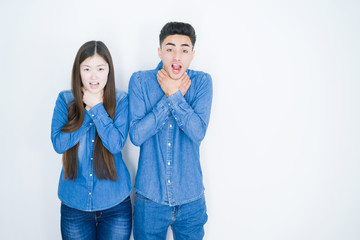 Fototapeta premium Beautiful young asian couple over white isolated background shouting and suffocate because painful strangle. Health problem. Asphyxiate and suicide concept.