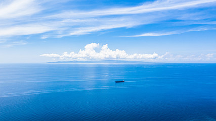 Aerial view blue sea water surface and blue sky, Beautiful white clouds on blue sky over calm sea with sunlight reflection, Oslob Philippines.