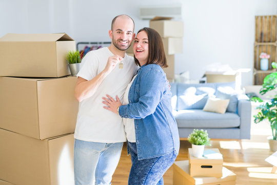 Young couple smiling very happy showing keys of new home, moving and buying new apartmet concept