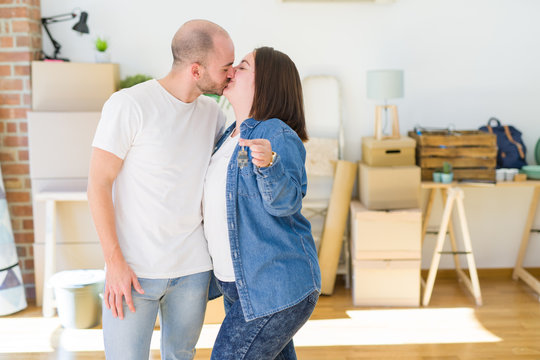 Young couple smiling very happy showing keys of new home, moving and buying new apartmet concept
