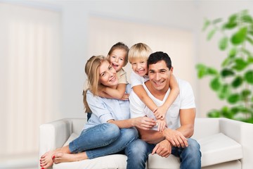 Fototapeta na wymiar Beautiful smiling family in room on couch