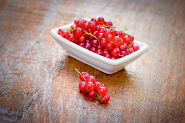 Red currant, organic currants on table and in white bowl