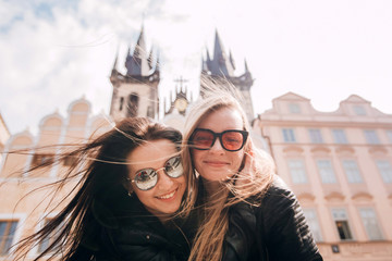 Girls, best friends are walking around Prague. Blonde and brunette enjoy traveling in Prague in the...