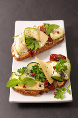 sandwich, bread with cheese, zucchini, and dried tomato with basil