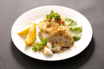 fish fillet cooked with crust , lemon and basil