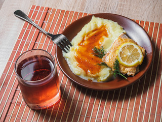 Fried fish with mashed potato and tea. Cafe table