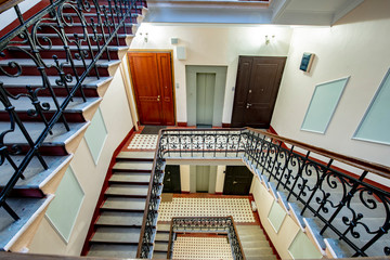 Obraz premium Staircase with forged railings on the railing in the old stairwell