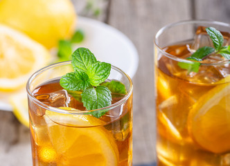 Fototapeta premium Glass of Refreshing Ice Tea With Lemon Slices and Mint Leaves