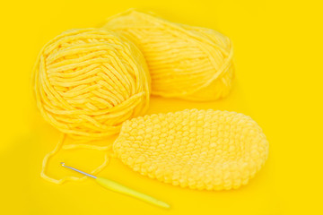 Color yarn for knitting, knitting needles and crochet hooks. Yelow background.