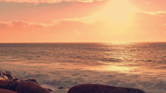Sunset on beach in Portugal, rocky coast with huge wawes of atlantic ocean.