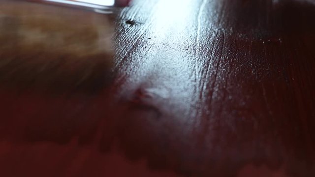painting Wood floor with a brush with the brown color close up