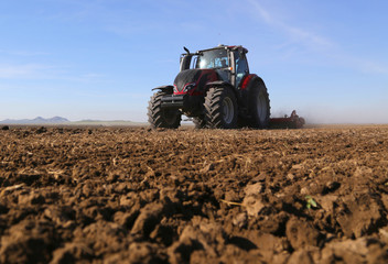 Obraz premium A farmer on a tractor prepares land for sowing.