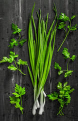 Cooking concept: raw green onion and parsley on black desk