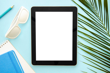 Top view mockup summer workspace. Tablet pc with notepad, sunglasses and palm leaf