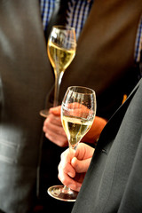 glasses of champagne in hands of groom