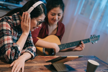 two young girl friends making video blog about musical instruments. beautiful woman in headphones...