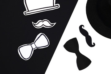 Father day concept.  Black and white paper  hat, mustache, bow, on black and white background. 